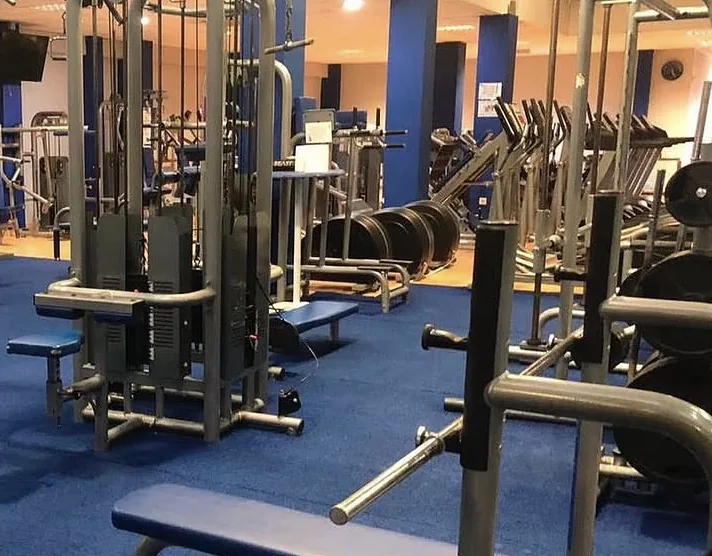Máquinas guiadas y discos en la sala de musculación